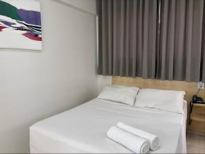 a bedroom with a bed with two towels on it at Hotel Itajaí Tur - Itajaí Navegantes in Itajaí