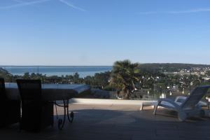 a balcony with a table and two chairs and the ocean at Maison avec vue sur Morgat in Crozon