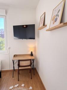 a room with a table with a lamp and a tv at Le COCON centre de Bethune in Béthune
