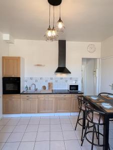 a kitchen with wooden cabinets and a table at Le COCON centre de Bethune in Béthune