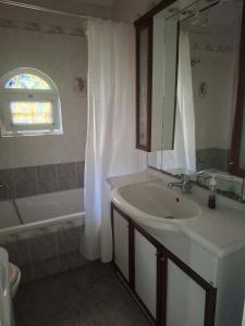 a bathroom with a sink and a tub and a mirror at Διαμερισμα επάνω στο κυμα in Kineta +16 photos