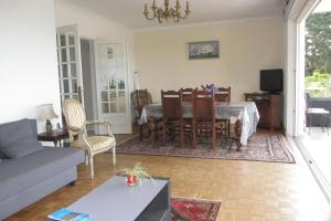 a living room with a table and chairs and a couch at Maison avec vue sur Morgat in Crozon