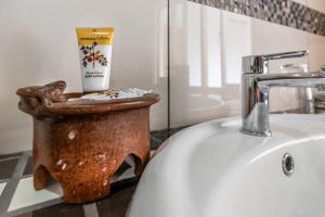 a bathroom with a sink and a cup of coffee at Ndumu Safari Resorts in Ingwavuma +14 photos