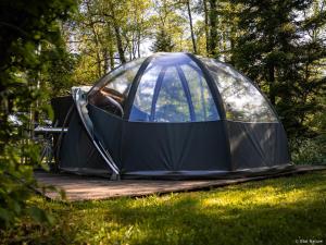 a tent sitting on a deck in the grass at Bulle forestière - Etat Nature in Magnières +19 photos