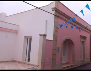 a pink and white building with blue flags on it at La Dormeuse in Vignacastrisi