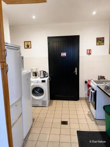 a black door in a kitchen with a washing machine at Bulle forestière - Etat Nature in Magnières