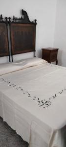 a bed with a white bedspread with a flower design on it at La Dormeuse in Vignacastrisi