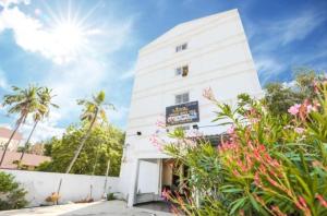a white building with flowers in front of it at Sunlux Villa in Pondicherry