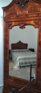 a reflection of a bed in a large mirror at La Dormeuse in Vignacastrisi