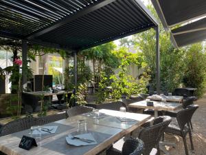 an outdoor dining area with tables and chairs at Hotel De La Mer in La Tranche-sur-Mer