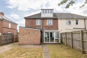 a brick house with a wooden fence at Billingham Rooms in Stockton-on-Tees