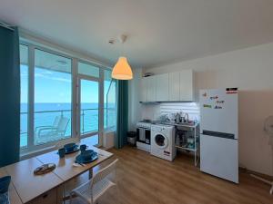 a kitchen with a white refrigerator and a table at Плажни Апартаменти Силвър Бийч - Silver Beach Sea Apartments in Byala