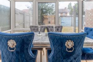 a dining room with blue chairs and a table at Billingham Rooms in Stockton-on-Tees