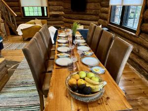 a long wooden table with a bowl of fruit on it at Villa Pukelo Arctic Lodge with wifi sauna 4 poster bed fireplace in Salla