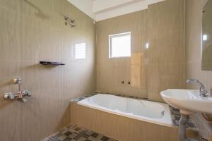 a bathroom with a tub and a sink at Sunlux Villa in Pondicherry +13 photos