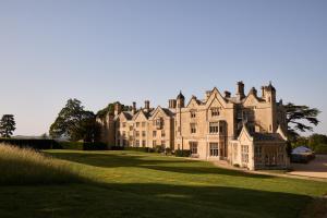 an old castle on a grassy field at Dumbleton Hall in Broadway