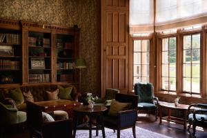 a living room with a couch and a table and chairs at Dumbleton Hall in Broadway