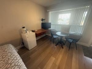 a room with a table and chairs and a television at Motel Brise Marine in Shippagan