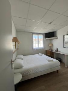 a bedroom with a large white bed and a desk at Hotel De La Mer in La Tranche-sur-Mer +49 photos