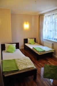 two beds in a room with a window at Willa Kalinowa in Sopot