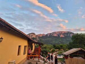 a group of people standing outside of a house with a mountain at Ramonda Serbica - Gorge View & Peacful Nature Retreat in Niš
