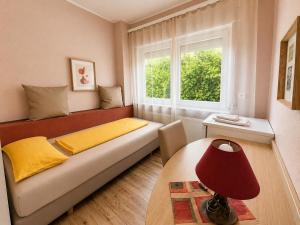 ein Wohnzimmer mit Sofa und Fenster in der Unterkunft Hotel-Heilsberg in Gottmadingen