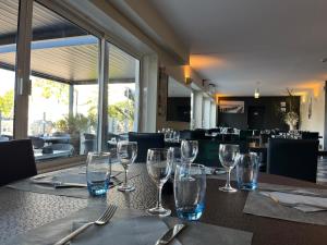 a table with wine glasses on a table in a restaurant at Hotel De La Mer in La Tranche-sur-Mer