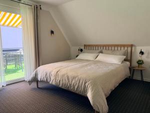 a bedroom with a bed and a large window at Haus Übernachtenswert Cochem Mosel in Cochem