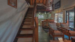 a staircase in a room with chairs and a table at Mahlolwa in Marloth Park