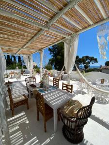 a patio with a table and chairs under a pergola at Villa Tropical in Francavilla al Mare