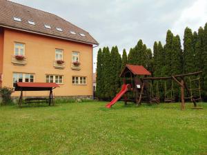 a playground in a yard next to a building at Pensiunea Praid - Parajd Panzió in Praid