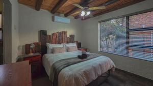 a bedroom with a bed and a ceiling fan at Mahlolwa in Marloth Park +30 photos