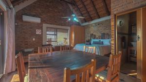 a dining room with a table and a bed at Mahlolwa in Marloth Park