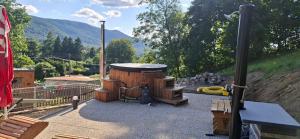 a small wooden building with a playground with mountains in the background at Chalupa pod Paličníkem in Weissbach