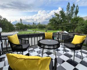 a patio with a table and chairs on a balcony at Hotel Desert Bloom Skardu in Skardu