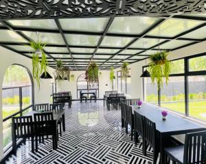 a dining room with tables and chairs and plants at Hotel Desert Bloom Skardu in Skardu