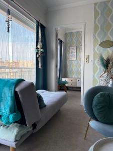 a bedroom with a couch and a large window at Ma Mère Beach Condo Oostende in Ostend
