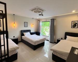 a bedroom with two beds and a window at Hotel Desert Bloom Skardu in Skardu