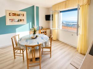 a dining room with a table and chairs and a window at PetlyApartments in Bellaria-Igea Marina