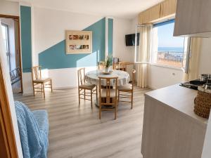 a kitchen and living room with a table and chairs at PetlyApartments in Bellaria-Igea Marina