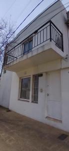 a white house with a balcony on top of it at Depto Rafaela in Rafaela