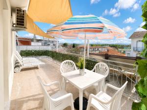 a patio with a table and chairs and an umbrella at PetlyApartments in Bellaria-Igea Marina