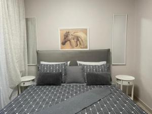 a bedroom with a bed with a horse picture on the wall at Olena Apartment in Nea Moudania