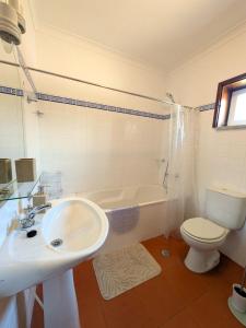 a bathroom with a sink and a toilet and a tub at Casa da Sofia in Ponte da Barca