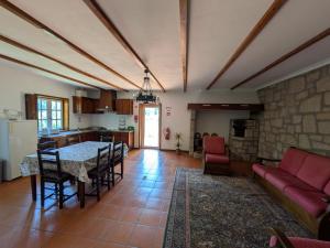 a kitchen and living room with a table and a couch at Casa da Sofia in Ponte da Barca