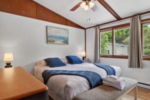 a bedroom with two beds and a table and windows at Egg Harbor Waterfront home in Egg Harbor