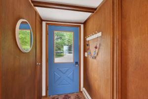 a hallway with a blue door and a mirror at Egg Harbor Waterfront home in Egg Harbor
