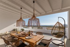 a dining room with a table and chairs and chandeliers at Naxian Pearl in Mikri Vigla