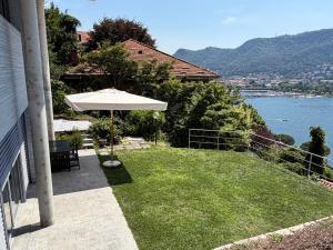 a patio with an umbrella and a view of the water at Prestigiosa vista lago in Como +59 photos