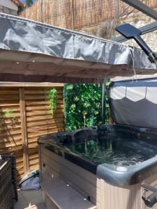 a jacuzzi tub in a backyard with a fence at Cabane insolite avec jacuzzi in Menton